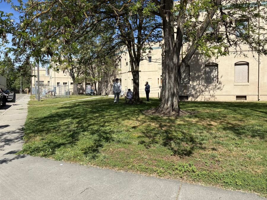 Historic San Joaquin General Hospital building under shade trees, site of the family practice clinic remodel